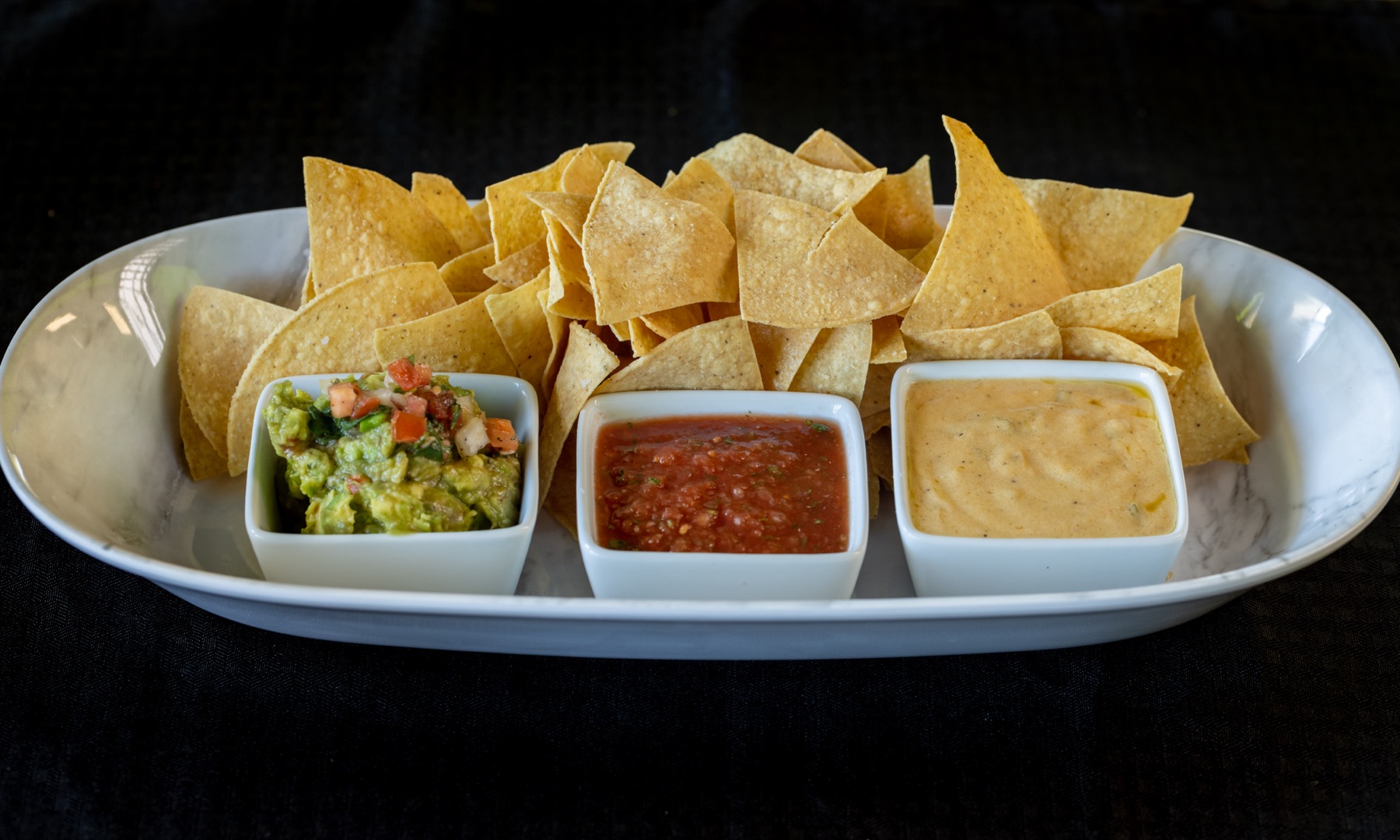 Chips with guacamole, salsa and queso